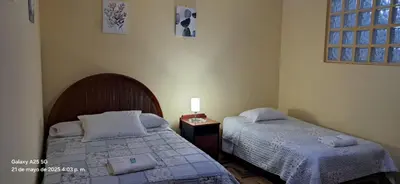a bedroom with two beds and a table with a lamp at Lopez House in Lima