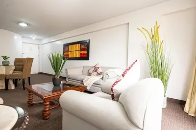 a living room with two couches and a table at Apart Hotel San Martin in Lima