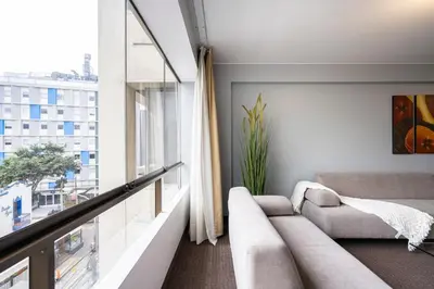 a living room with a couch and a large window at Apart Hotel San Martin in Lima