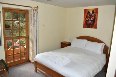 a bedroom with a bed and a window at Apu Lodge in Ollantaytambo