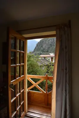 an open door with a view of a mountain at Apu Lodge in Ollantaytambo