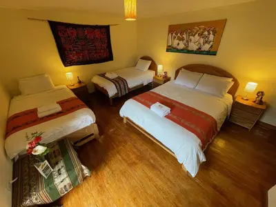 a hotel room with two beds and two lamps at Apu Lodge in Ollantaytambo