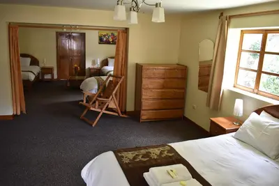 a hotel room with two beds and a mirror at Apu Lodge in Ollantaytambo