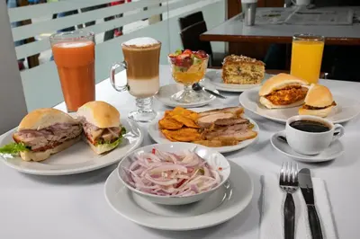 a table topped with plates of sandwiches and drinks at Hotel Chavín in Barranca