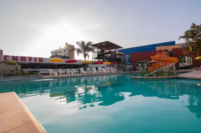 a large swimming pool with chairs and a water slide at Hotel Chavín in Barranca
