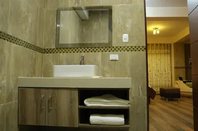 a bathroom with a sink and a mirror at hotel el parral suite in Ica