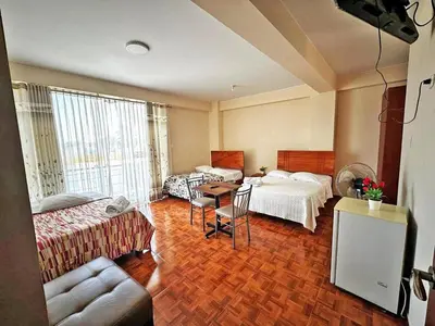 a hotel room with two beds and a table at hotel el parral suite in Ica