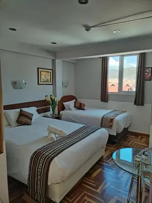 a hotel room with two beds and a window at HOTEL AMTALLPA San Blas Inn in Cusco