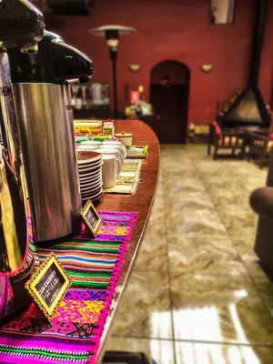 a table with plates and dishes on top of it at HOTEL AMTALLPA San Blas Inn in Cusco