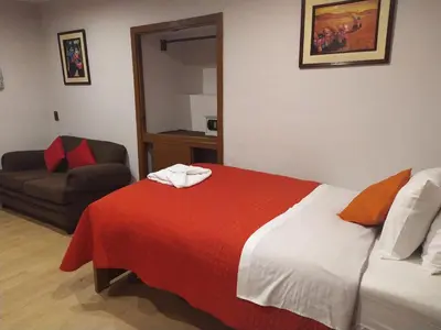 a hotel room with a bed and a chair at HOTEL AMTALLPA San Blas Inn in Cusco