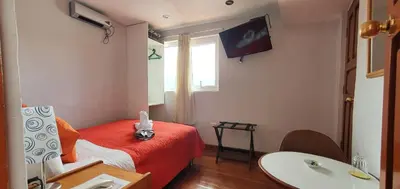 a hotel room with a red bed and a sink at HOTEL AMTALLPA San Blas Inn in Cusco