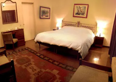 a bedroom with a bed and a table and a mirror at Hotel Majoro in Nazca