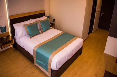a bedroom with a large bed with blue pillows at Hotel Diamond Lima in Lima