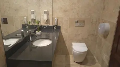 a bathroom with two sinks and a toilet and phones at Hotel Las Lomas in Lima