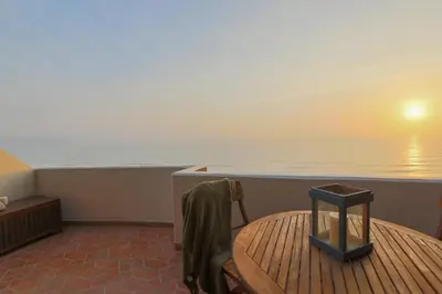 a balcony of a boat with a table and the ocean at Oceanfront Penthouse in Miraflores in Lima
