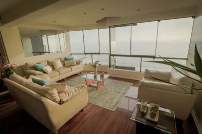 a large living room with couches and a large window at Oceanfront Penthouse in Miraflores in Lima