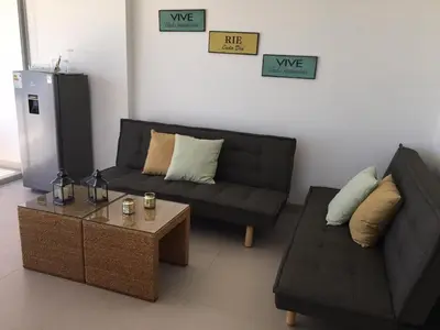 a living room with a couch and a coffee table at Paracas departamento Condominio Nautico in Paracas