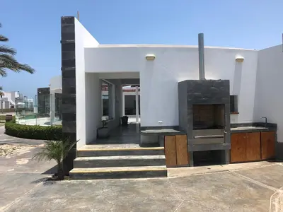 a house with a fireplace on the side of it at Paracas departamento Condominio Nautico in Paracas