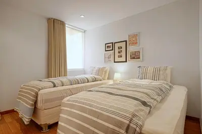 two beds in a room with a window at InkaHuset Pacasmayo in Lima