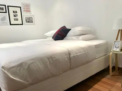 a white bed with white sheets and pillows on it at InkaHuset Pacasmayo in Lima
