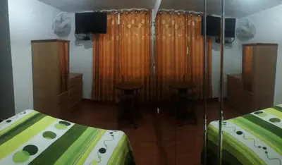 a bedroom with a bed and two stools in it at Hostal Sueños in Lima
