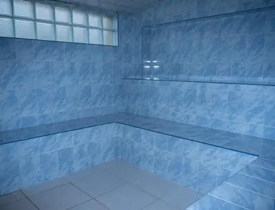 a blue tiled shower with a bench in a bathroom at Hostal Sueños in Lima