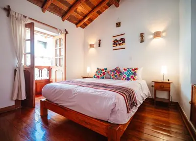 a bedroom with a large bed and a window at Picaflor Tambo Guest House in Ollantaytambo