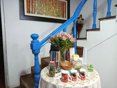 a table with drinks and a vase of flowers at Posada Azul Cusco in Cusco