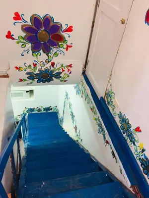 a staircase with a flower mural on the wall at Apartamento Cusco Queswa in Cusco