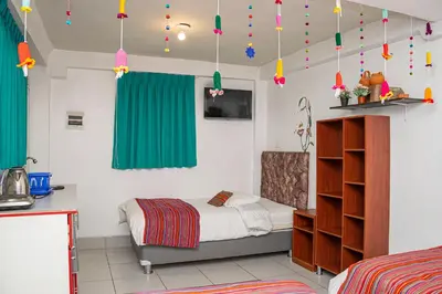 a bedroom with a bed and green curtains at Magic Cusco in Cusco