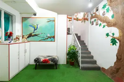 a room with a staircase with a painting and green carpet at Magic Cusco in Cusco