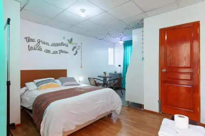 a bedroom with a bed with a sign on the wall at Magic Cusco in Cusco