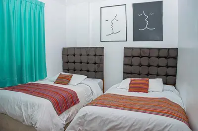 two beds sitting next to each other in a bedroom at Magic Cusco in Cusco