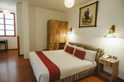 a hotel room with a bed and a couch at Hotel Monasterio San Pedro in Cusco
