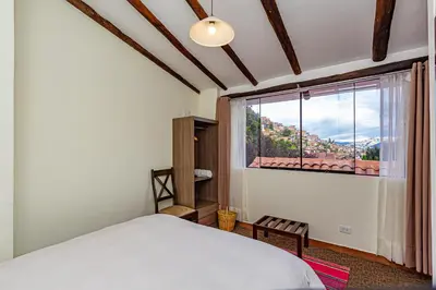 a bedroom with a bed and a large window at Luna House Cusco in Cusco