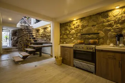 a kitchen with a stove and a stone wall at Luna House Cusco in Cusco