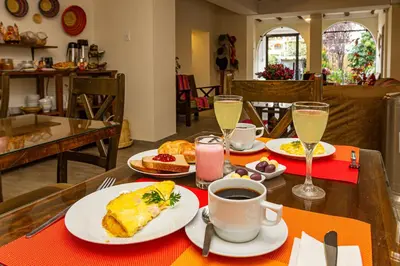 a table topped with plates of food and a cup of coffee at Luna House Cusco in Cusco