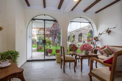 a living room with arched doors and a table and chairs at Luna House Cusco in Cusco