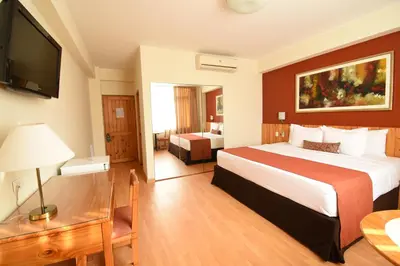 a hotel room with a bed and a television at Qorianka Hotel in Lima