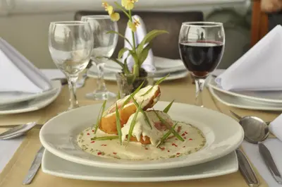 a plate of food on a table with wine glasses at Qorianka Hotel in Lima