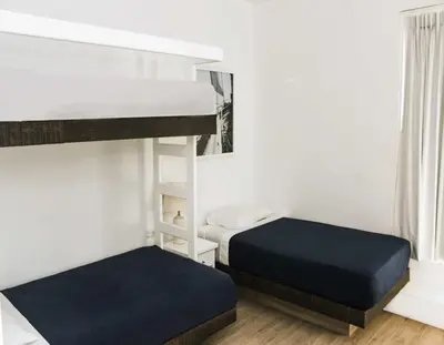 a bedroom with two bunk beds and a window at Casa Paracas in Paracas