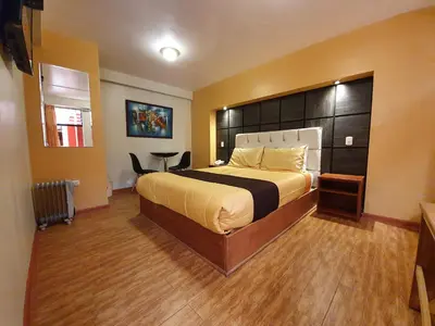 a bedroom with a large bed with a large headboard at El Mariscal Cusco in Cusco