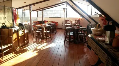a restaurant with wooden floors and tables and windows at Hatun Quilla in Cusco