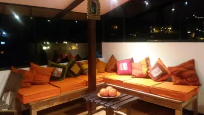 a couch with colorful pillows on it in a room at Hatun Quilla in Cusco