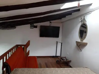 a bedroom with a bed and a television on a wall at Hatun Quilla in Cusco