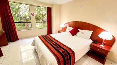 a bedroom with a large bed and a large window at La Mansion Casa Hotel in Andahuaylas