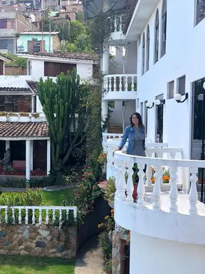 a woman standing on a balcony of a house at La Mansion Casa Hotel in Andahuaylas