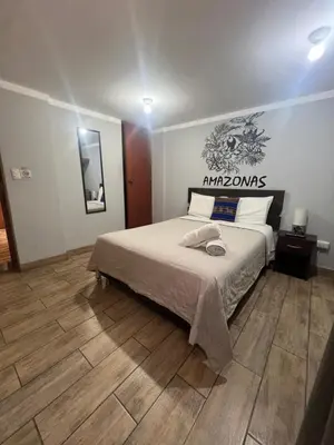 a bedroom with a bed and a wooden floor at Lima Airport Tampu in Lima