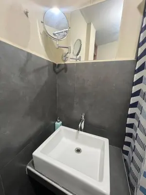 a white sink in a bathroom with a mirror at Lima Airport Tampu in Lima