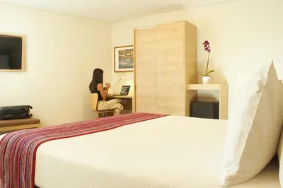 a woman sitting at a desk in a hotel room at Xima Lima San Isidro in Lima